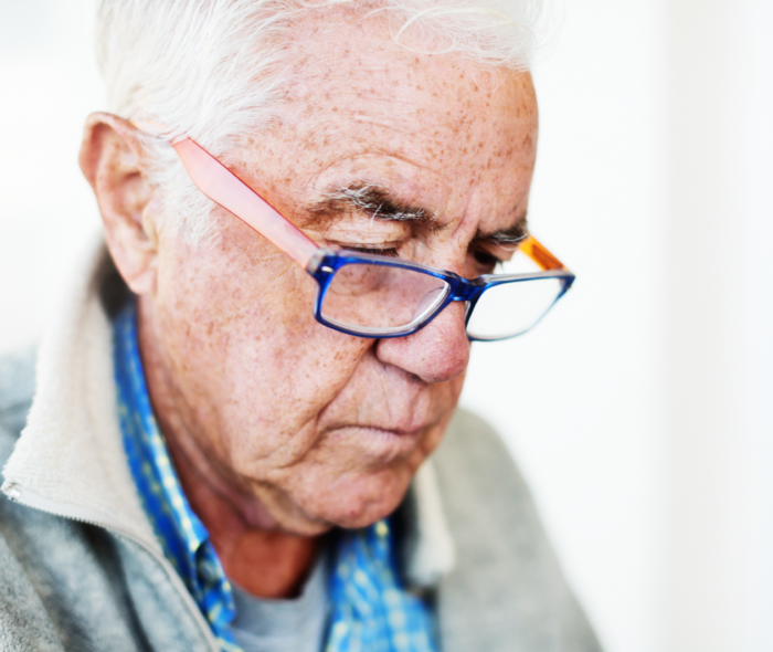Leben mit fortgeschrittenem Prostatakarzinom: Ein Mann mit Brille blickt etwas nach unten und liest. Ein Mann mit Brille blickt etwas nach unten und liest.