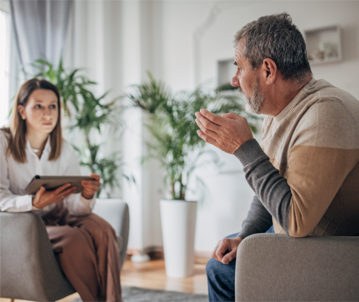 Leben mit Prostatakrebs: Ein Mann und eine Frau sitzen sich gegenüber und unterhalten sich. Ein Mann und eine Frau sitzen sich gegenüber und unterhalten sich.