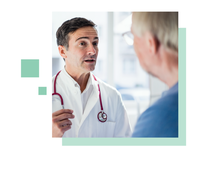 Leben mit Prostatakrebs: Ein Arzt steht einem Patienten gegenüber und spricht. Ein Arzt steht einem Patienten gegenüber und spricht.