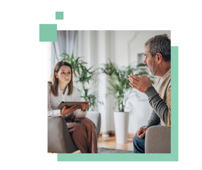 Ein Mann und eine Frau sitzen sich gegenüber und unterhalten sich.