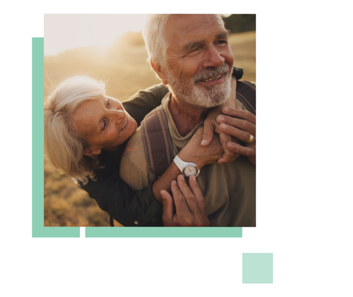 Frau umarmt glücklich ihren Mann von hinten.