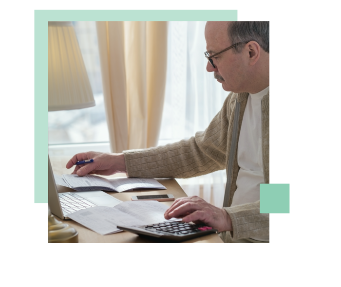 Ein Herr sitzt am Schreibtisch und liest Dokumente.