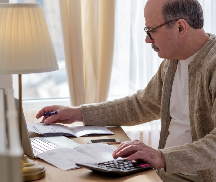 Ein Herr sitzt am Schreibtisch und liest Dokumente.