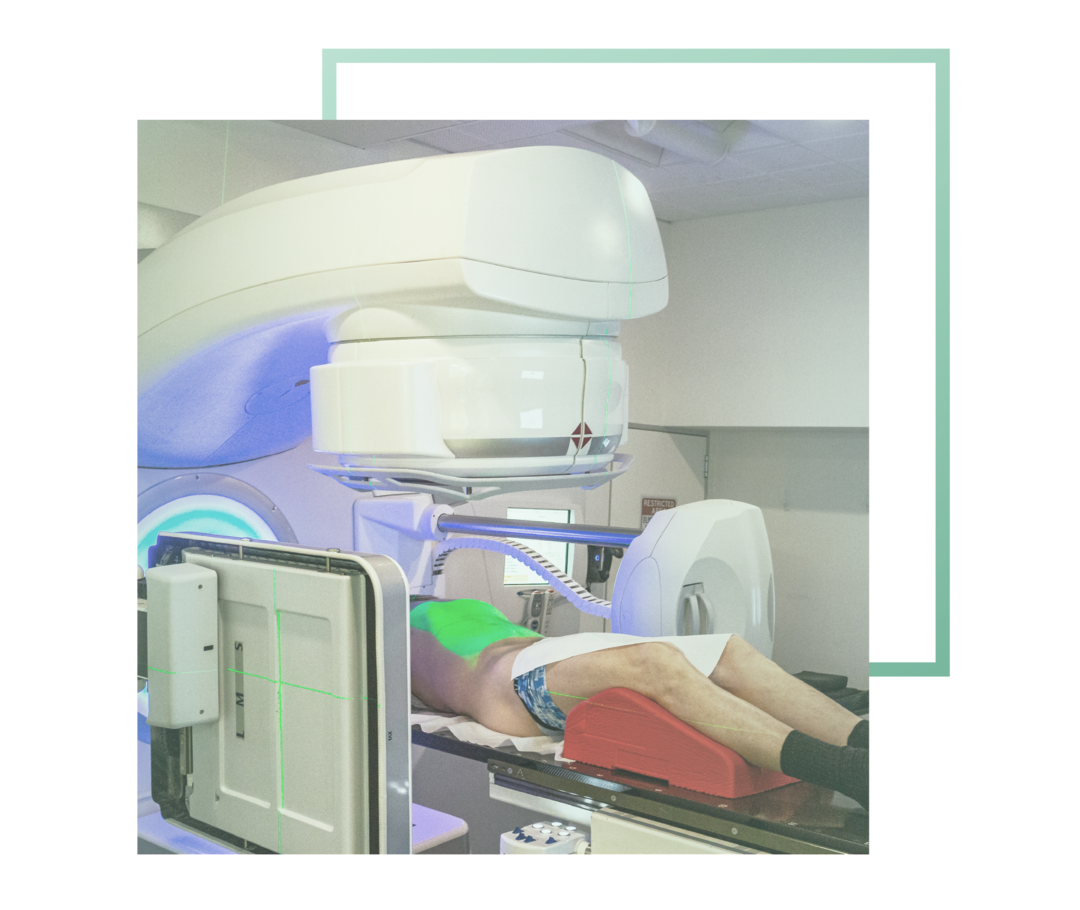 Das Foto zeigt einen Patienten, der unter einem Linearbeschleuniger liegt. 