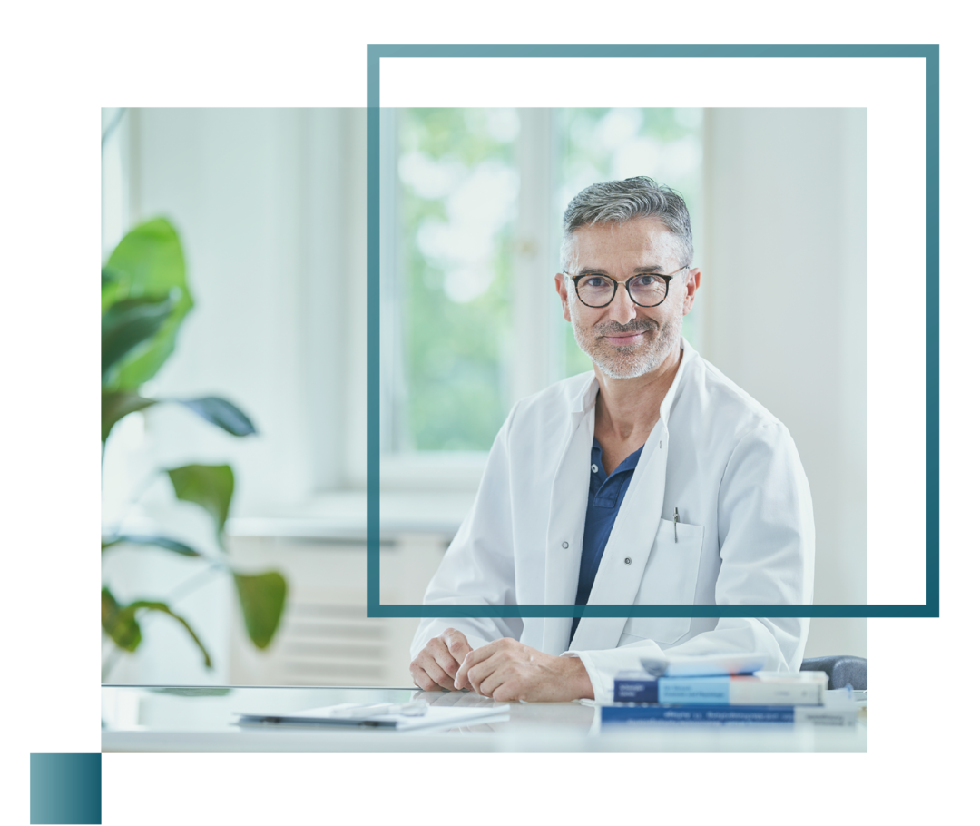 Leben mit fortgeschrittenem Prostatakarzinom: Ein Arzt sitzt an einem Schreibtisch und blickt in die Kamera. Ein Arzt sitzt an einem Schreibtisch und blickt in die Kamera.