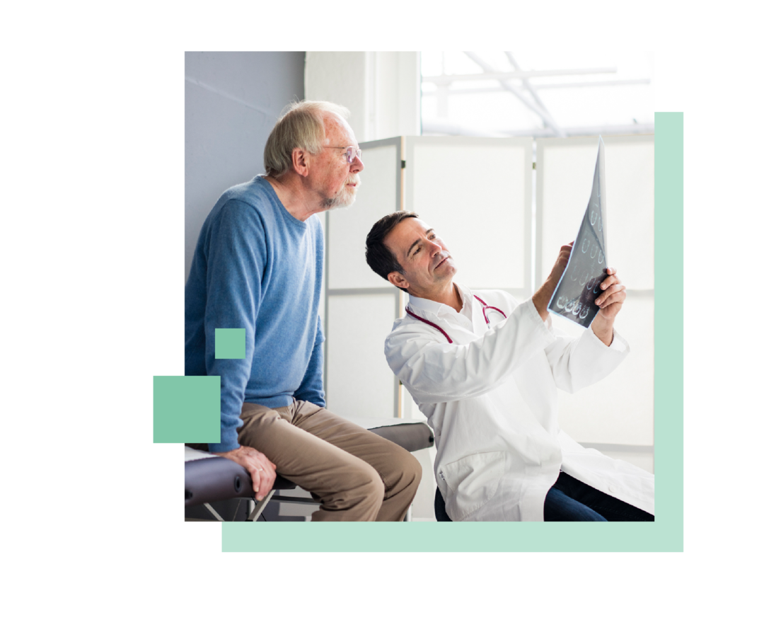 Leben mit Prostatakrebs: Ein Mann sitzt auf einer Liege und bespricht mit einem Arzt ein diagnostisches Bild. Ein Mann sitzt auf einer Liege und bespricht mit einem Arzt ein diagnostisches Bild.