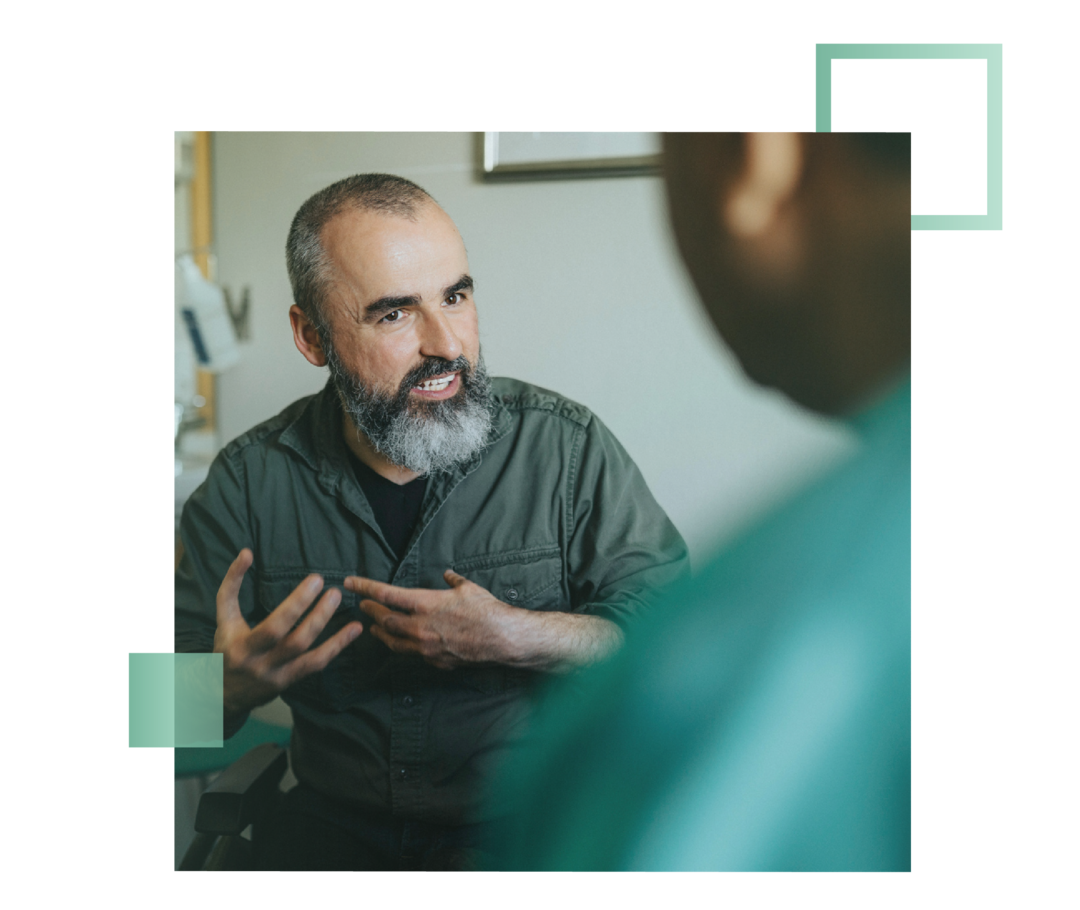 Ein Mann mit Bart spricht mit einer Schwester. 