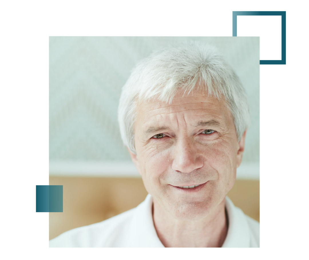 Älterer Mann mit weißen Haaren und leichtem Lächeln.