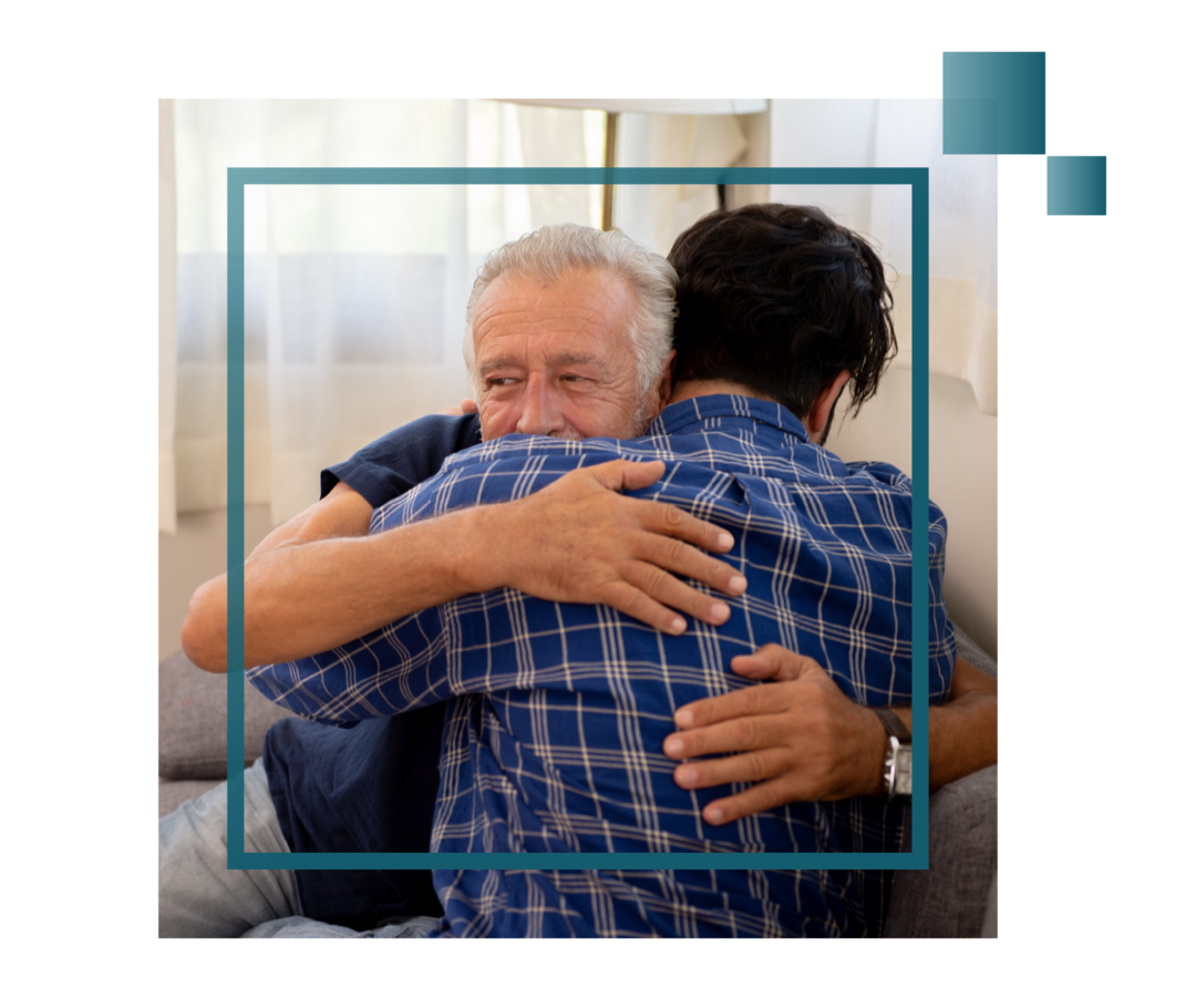 Älterer Herr umarmt glücklich seinen Engelsohn.