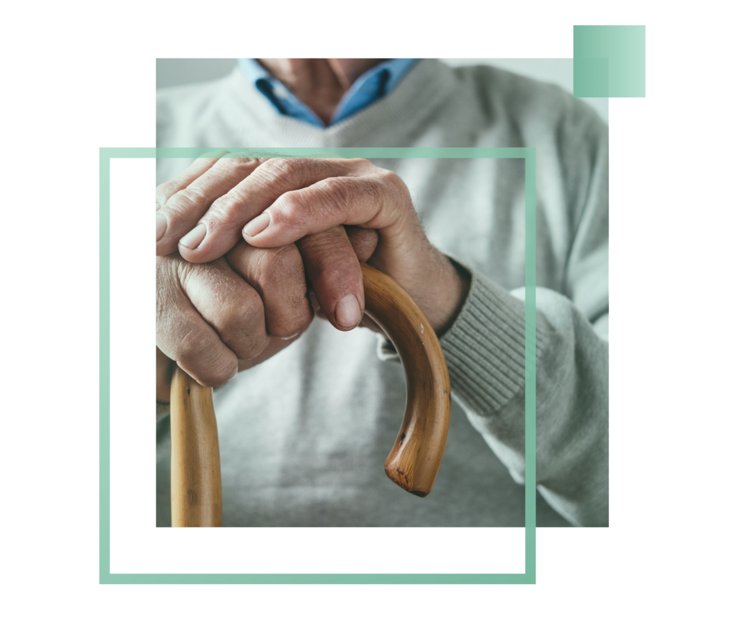 Nahaufnahme von männlichen Händen an einem Gehstock.