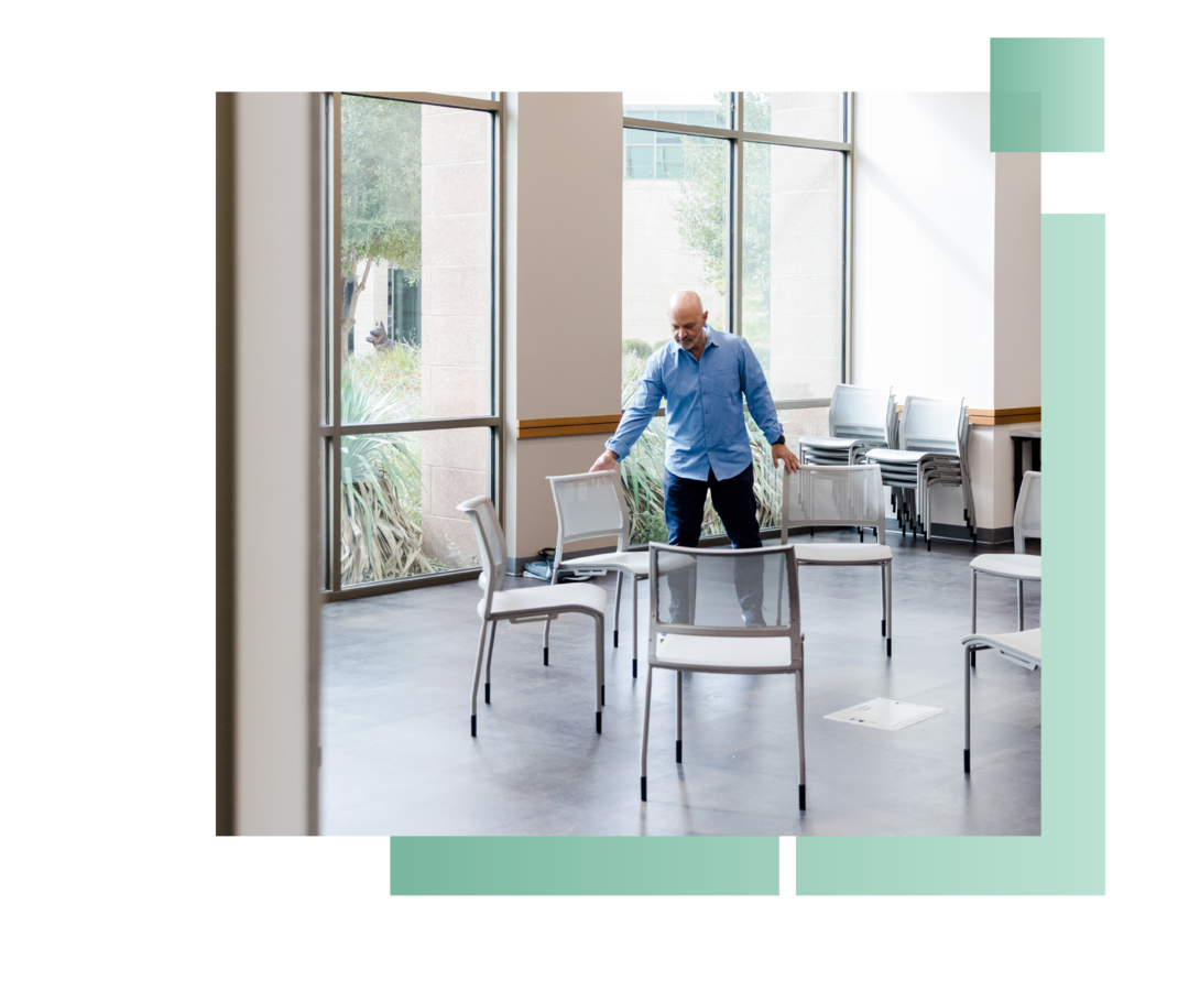 Mann bei der Vorbereitung eines Stuhlkreises.